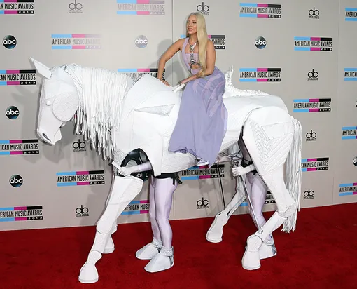 Леди Гага на лошади, которой управляют два мужчины