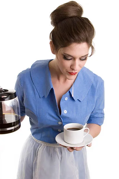 женщина держит в одной руке чашку с кофе, в другой кофейник и слпевывает