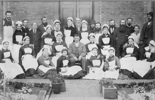 Персонал Веллингтонского госпиталя в 1885 году, незадолго до поступления Кэт Марсден на работу. Сидящий мужчина в центре снимка — доктор Морис Чилтон. Стоящая левее и сзади него женщина — главная сестра Мэри Кисслинг