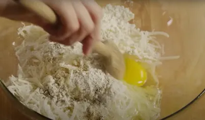 Пока почистим лук и мелко нарезаем половину луковицы. Теперь к картофелю добавляем лук, муку и яйцо и перемешиваем до однородной массы.