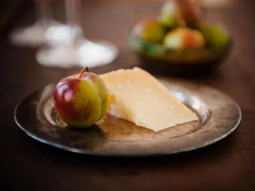 Яблоко и кусок твердого сыра на тарелке