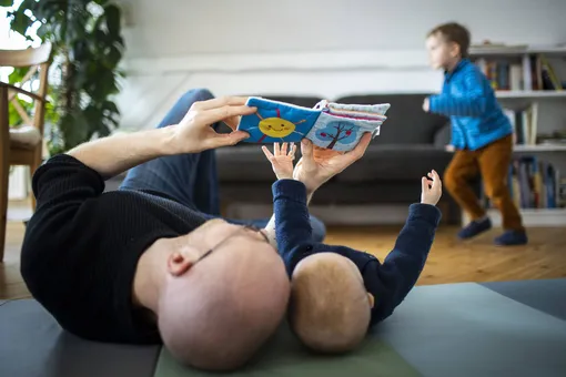Папа с малышом разглядывают книжку-игрушку