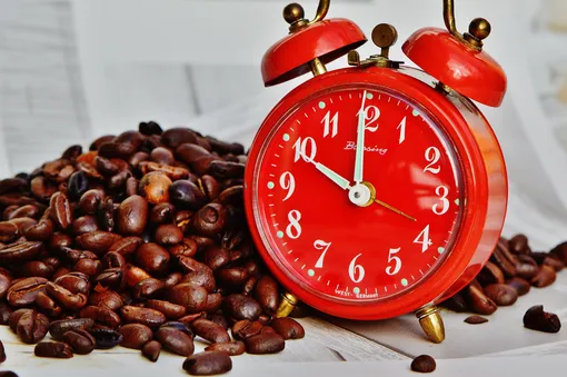 красный будильник и зерна кофе