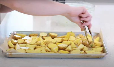 Переложите картофель на противень. Разровняйте и запекайте от 45 минут до 1 часа. Должна образоваться румяная корочка. Во время готовки перемешайте картофель два раза, так он получит равномерную корочку.
