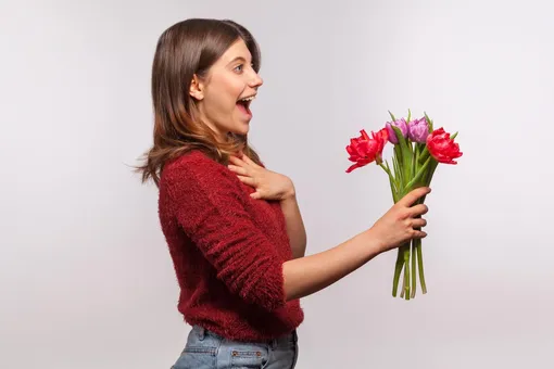 Девушка эмоционально радуется цветам Поздравления с 8 марта подруге