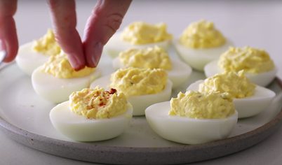 Выложите желтковую массу на белки. Посыпьте фаршированные яйца паприкой и подавайте.
