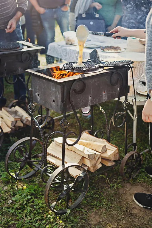 Мангал на колесиках, мужчина готовит вафли на мангале