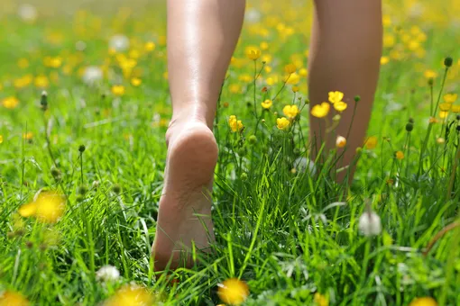 девушка ходит босиком в траве