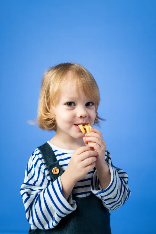 Ребёнок ест картофель фри