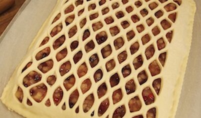 Получившейся сеткой накройте пирог сверху. Края сетки и нижней части прижмите друг к другу и обрежьте так, чтобы толщина края теста была равна толщине самого теста. Дать пирогу подойти в теплом месте. Поставьте дрожжевой пирог с яблоками и брусникой в разогретую до 200 градусов духовку и выпекайте при температуре 180-200С 30-35 минут. Теперь вы знаете, как приготовить пирог с яблоком и брусникой!