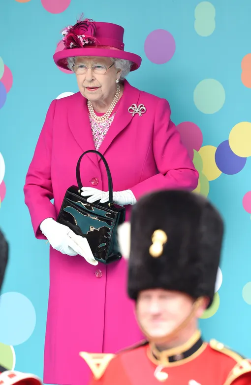 Королева держит сумку в руках