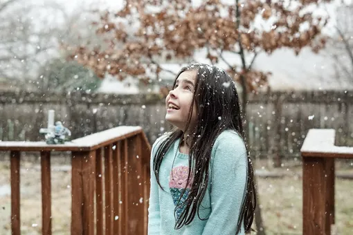 девочка без шапки во время снегопада