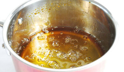 Когда сироп стал золотисто-янтарным, снимите его с плиты и поставьте на жаропрочную подставку на стол. 
Будьте осторожны, не давайте сиропу потемнеть на плите. Цвет будет темнеть некоторое время и после того, как вы сняли сироп с плиты. 


Дайте сиропу для сахарной ваты в домашних условиях остыть 5-7 минут.
