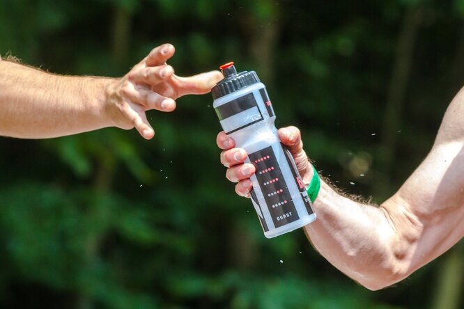 мужчины передают бутылку с водой