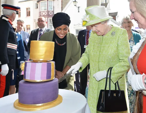 Корелева Елизавета II разрезает торт, приготовленный известным кондитером Надей Сулейман