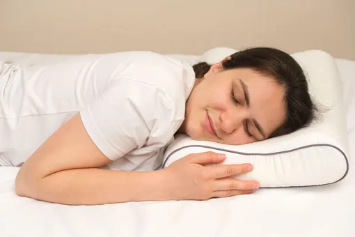 девушка спит, обняв ортопедическую подушку