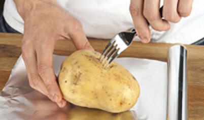 Картофель не чистите, тщательно вымойте, обсушите и проколите вилкой поперек.