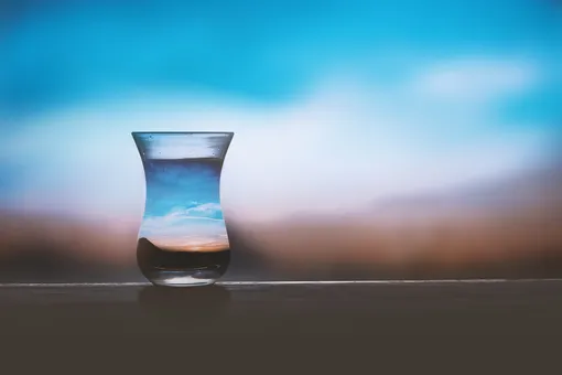 вода в стакане на фоне неба