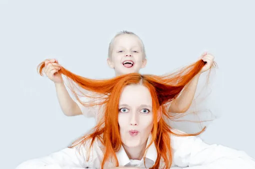 ребенок играет с волосами мамы
