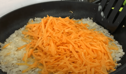 Пока коржи остывают, приготовьте начинку для печёночного торта. Нарежьте лук полукольцами – тонкими, это важно. Потрите морковь на крупной терке. Если вам покажется, что овощей маловато, добавьте еще луковку и морковку. Обжарьте овощи на растительном масле.
