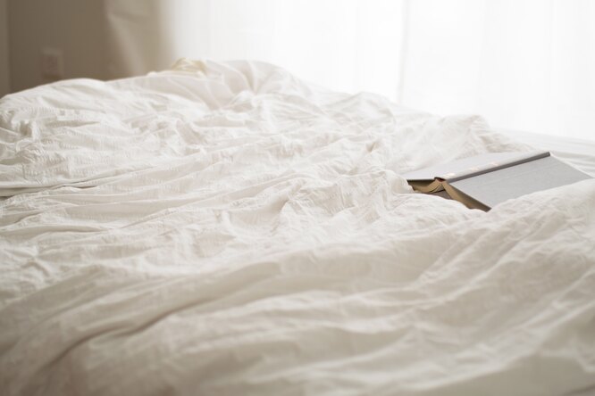 смятая постель и раскрытая книга