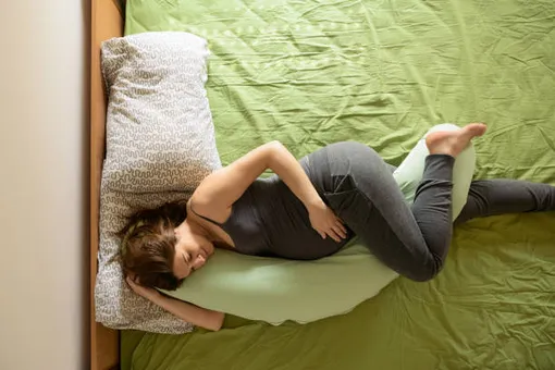 беременная женщина спит на подушке для беременных