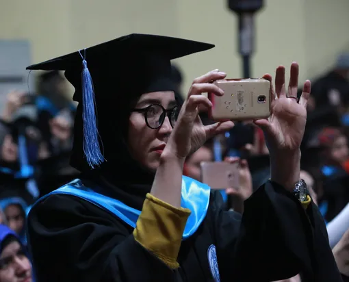 Выпускница Университета Кабула снимает на смартфон церемонию вручения дипломов, 2020 год