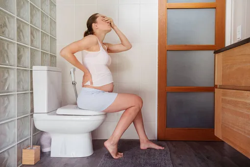 Беременная женщина в туалетной комнате