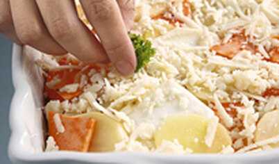 Посыпьте овощи тертым сыром и зеленью. Повторите слои до заполнения формы.