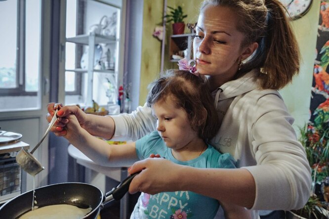 Мама помогает Полине наливать тесто на сковородку