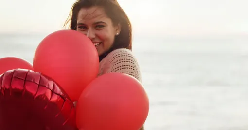 Девушка с красными шариками улыбается, цитаты о любви к себе