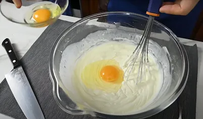 Добавляйте яйца по одному и тщательно, но осторожно перемешивайте. Теперь используйте только лопатку. Если перестараться и начать взбивать массу – она станет жидкой.