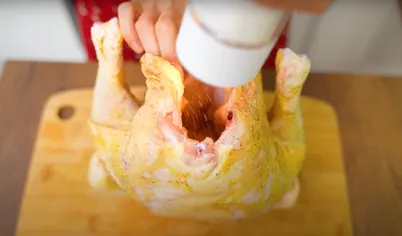 Положите половину масла внутрь курицы, остальную часть – под кожу. Для этого осторожно надорвите кожу сверху грудки и отделите её от мяса. В свободную полость положите масло. Нарежьте сельдерей крупными кусками и положите внутрь курицы.