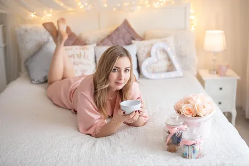 Девушка на кровати с чаем и подарками на 8 марта