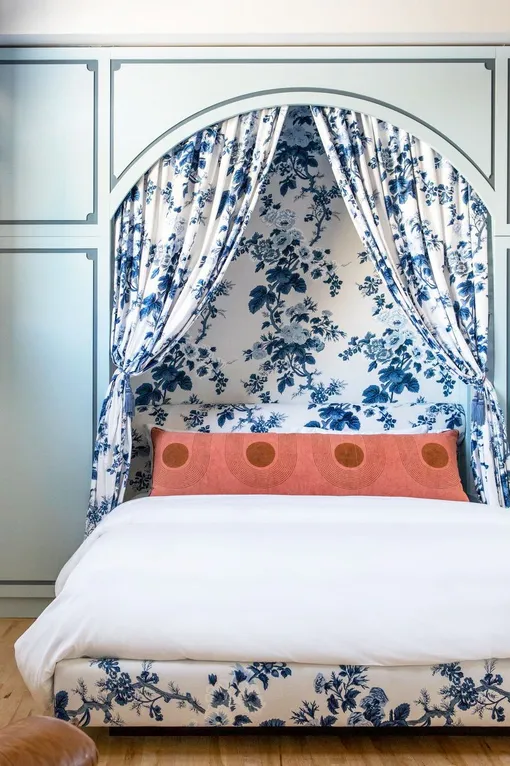 Спальня с занавесками и современной подушкой оранжевого цвета
