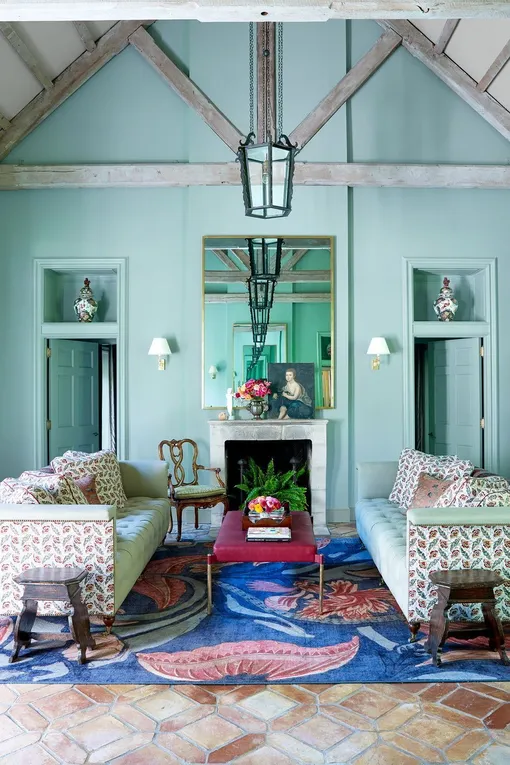 Мятно-зелёная гостиная с сине-красным ковром в загородном доме