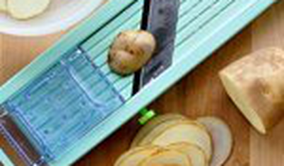 Тонко нарежьте картофель на терке-слайсере или острым кухонным ножом. Толщина ломтиков должна быть примерно 3 мм.