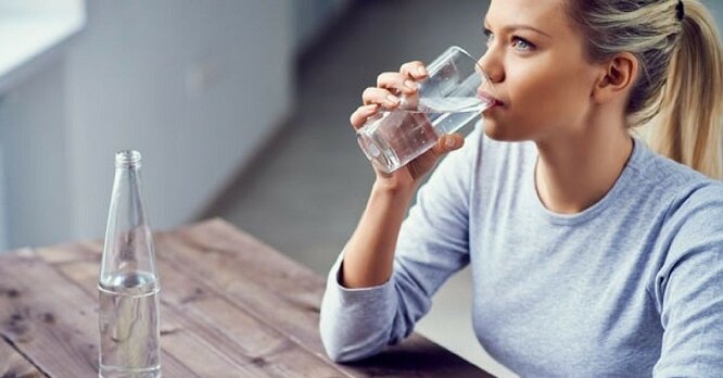 Девушка пьёт воду, как сжечь 1000 калорий в домашних условиях