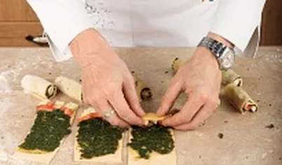 Сбрызните начинку оливковым маслом, сверните в плотные рулетики все тесто с начинкой.