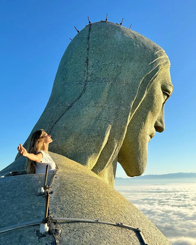 Жизель Бюндхен рядом со Статуей Христа-Искупителя в Рио-де-Жанейро. Входит в список «Новых семи чудес света».