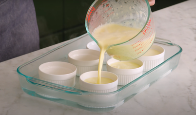 Взбейте в миске половину сахара и яичные желтки, пока она не побелеют. Вливайте постепенно сливки, постоянно помешивая. Разлейте смесь по рамекинам и поставьте в большую форму для выпекания. Налейте столько горячей воды, чтобы она касалась краёв формочек. Выпекайте крем-брюле около 40-45 минут.
