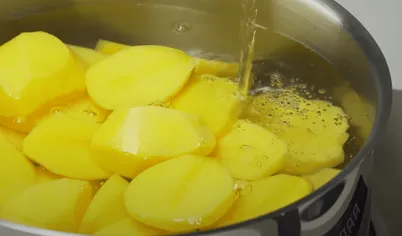 Для приготовления картофельной запеканки с фаршем порежьте очищенный картофель на небольшие кусочки и поставьте вариться до готовности. Чем мельче порежете, тем быстрее картофель сварится.
