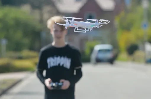 мальчик управляет летающим дроном