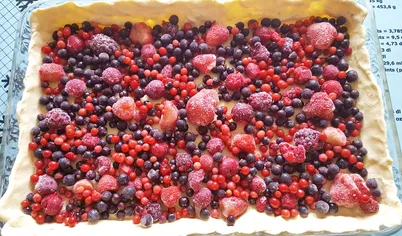 Сверху на тесто положить любые ягоды. Для заливки смешать в блендере творог, молоко, сметану, сахар, яйцо и муку. Залить сверху ягоды.
