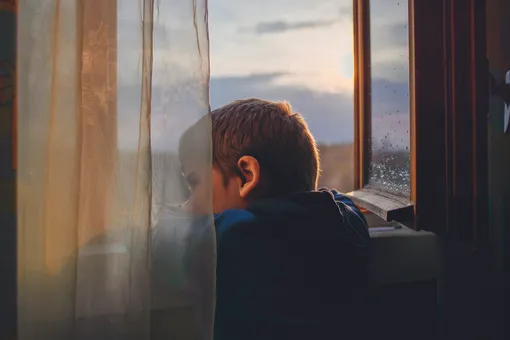 Мальчик смотрит в окно