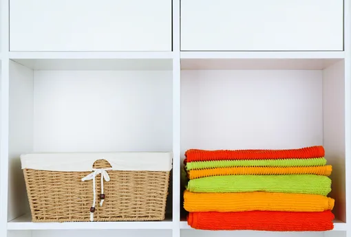 полотенца и корзина на полках шкафа