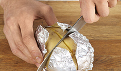 Готовый картофель разверните и сделайте сверху крестообразный надрез.