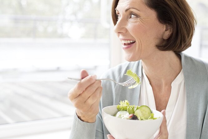 Женщина ест салат, похудение после 50 лет