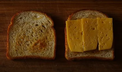 Разогреваем сковороду на среднем огне. Берём ломтик хлеба и смазываем его маслом. Кладём хлеб маслом вниз на разогретую сковороду, а сверху — ломтик сыра.

