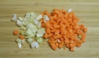 Поставьте воду на огонь. Морковь и лук порежьте небольшими кусочками.